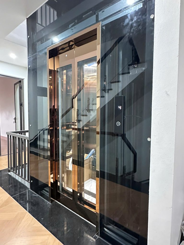 Cửa tầng thang máy gia đình có ô kính quan sát và bảng hiển thị tầng, lắp tại tầng bốn nhà phố ở Lục Nam