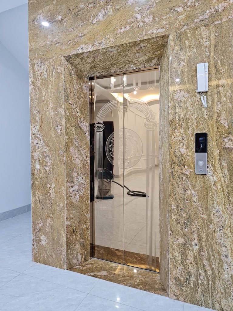 Cửa tầng thang máy khách sạn Bắc Giang ốp inox titan vàng ăn mòn hoa văn, bao quanh bằng đá granite tại Khách sạn Bình Ánh, Lục Nam