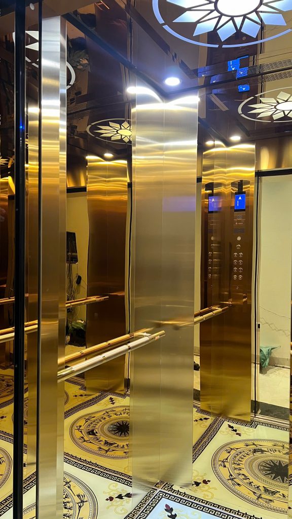 Bảng điều khiển và tay vịn inox trong cabin thang máy tải khách Yên Dũng, hai bảng gọi tầng bố trí đối xứng hai bên cabin